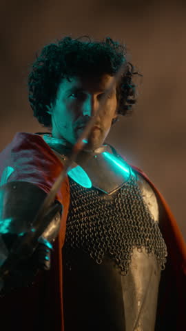 Portrait of Caucasian young adult knight holding sword blade in armor. Clip suitable for medieval fantasy marketing, gaming teasers, or cinematic historical storytelling, vertical