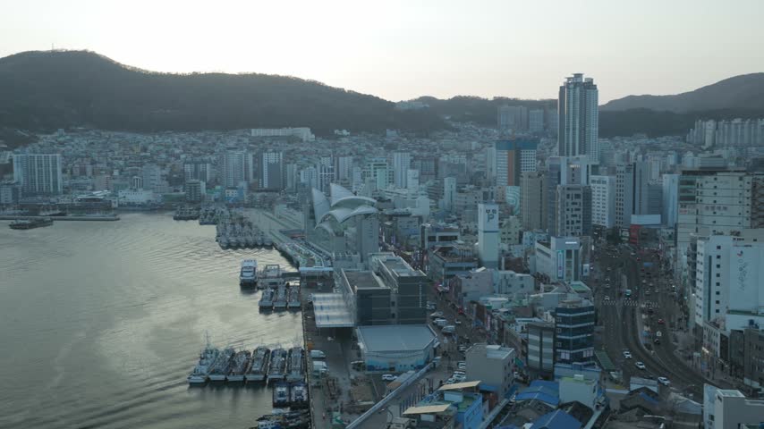 Port Harbour At The Busy Waterfront of Busan, South Korea, With Maritime Infrastructure And Coastal Cityscape. Aerial Shot