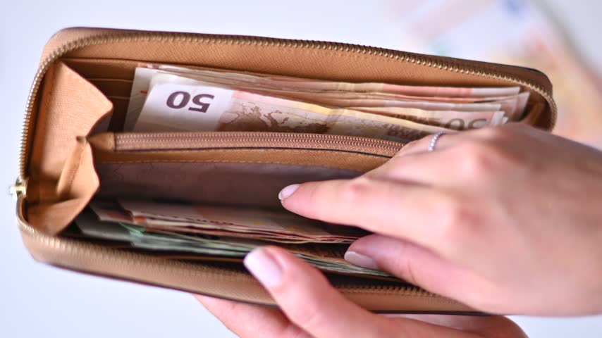 Woman hands holding brown leather wallet and counting euro banknotes closeup. Money financial management concept at home. High quality footage showing cash savings and wealth.