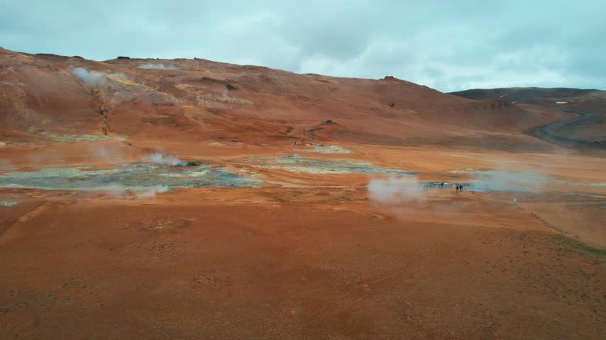 Stunning aerial view of the Hverir geothermal area near Lake Myvatn, showcasing steam vents, boiling mud pots, and the surreal Namafjall mountain