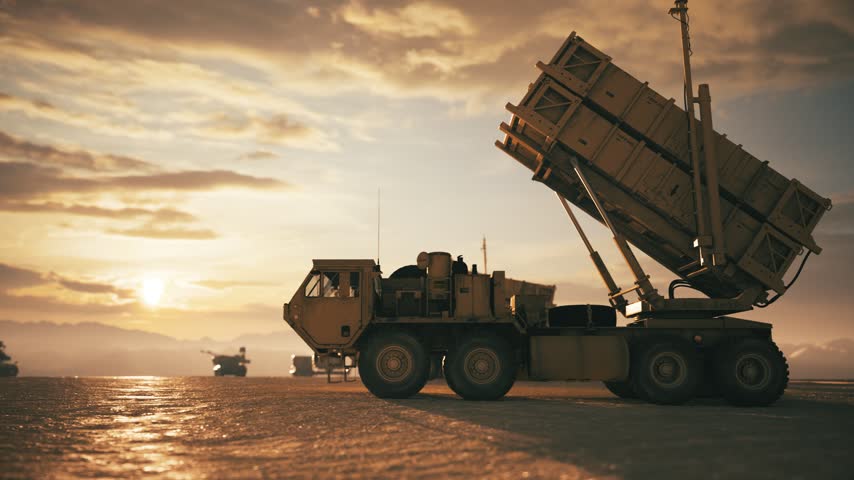 Military Missile Launchers and Armored Vehicles at Sunset. Patriot Air Defense Missile Systems