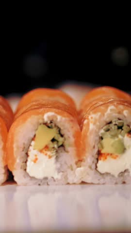 Traditional Japanese food. close-up. professional Sushi Chef is putting freshly prepared sushi rolls in a delivery box for takeaway from sushi bar.