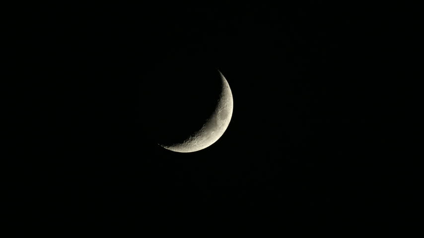 Detailed close up of a waxing crescent moon illuminated against a deep black night sky