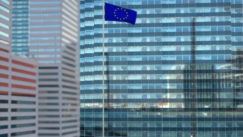 European Union Flag Waving Against Glass Office Building - Daylight Scene
