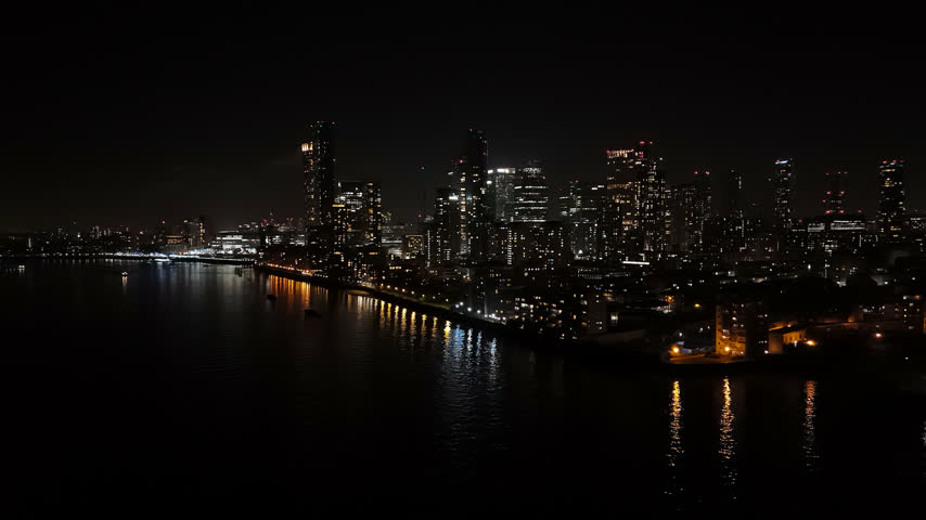 Aerial view rising toward the Canary Wharf skyline, night in London, England