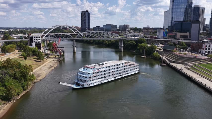 Drone aerial shot of a sightseeing boat as it turns around on the Cumberland River just outside of Nashville downtown