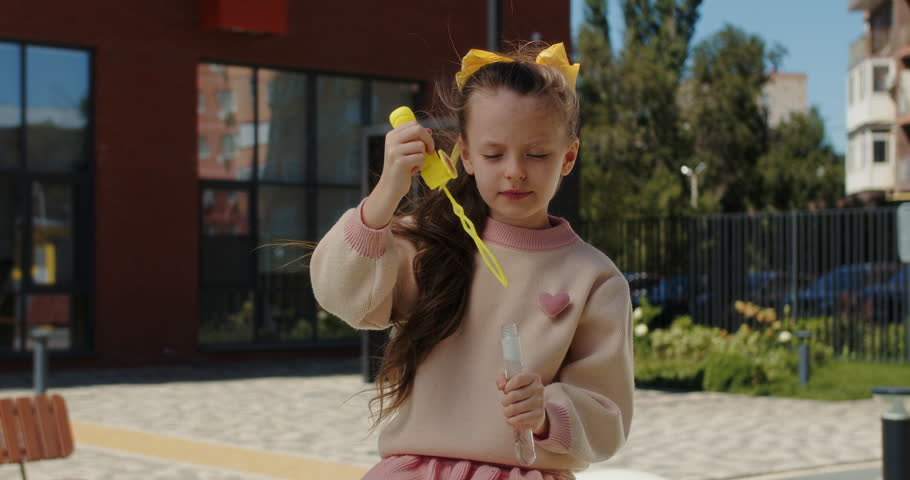 Girl blowing soap bubbles outdoors