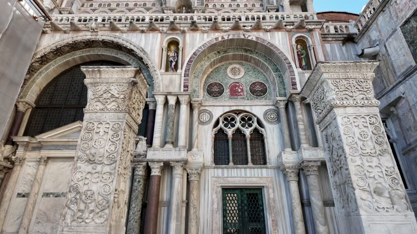 Front view of St. Mark’s Basilica from Piazza San Marco, capturing colorful mosaics and detailed Byzantine-inspired architecture under a clear blue sky
