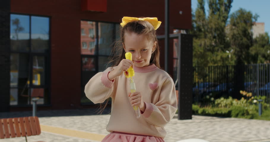 Girl blowing soap bubbles outdoors