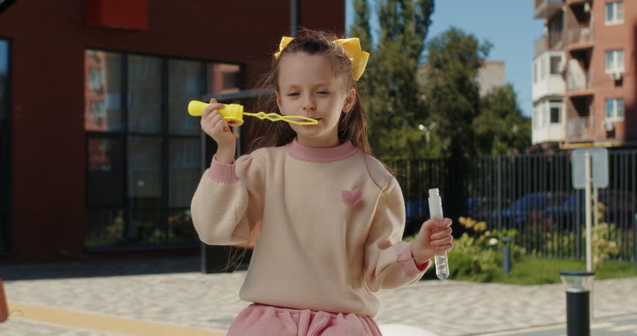 Girl blowing soap bubbles outdoors