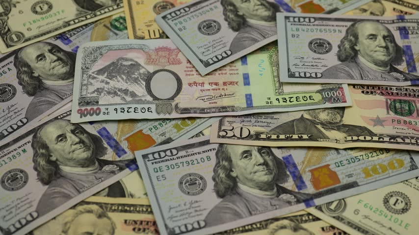 United States dollar banknotes arranged together with Nepal Rupee to display the familiar green currency used throughout the United States, featuring different denominations with detailed portraits of historical American figures, national symbols, engraved patterns, serial numbers, seals, and intricate security elements. The video captures close-up views of the paper currency, highlighting its distinctive design, fine printing details, layered textures, and variations in denomination. The arrangement creates a clear visual representation of American money and everyday cash, conveying themes of finance, banking, savings, spending, business, investment, commerce, currency exchange, and the global economy. Detailed framing and natural movement emphasize the recognizable characteristics of dollar bills while creating a practical financial background for economic, commercial, educational, and travel-related content.