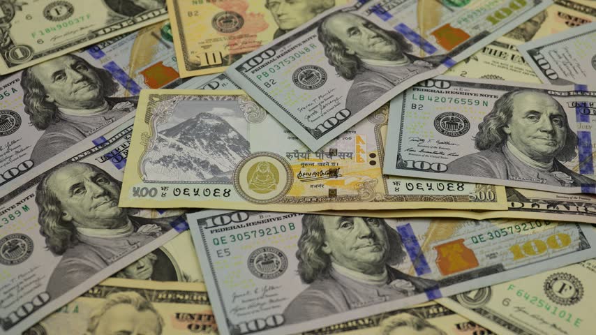 United States dollar banknotes arranged together with Nepal Rupee to display the familiar green currency used throughout the United States, featuring different denominations with detailed portraits of historical American figures, national symbols, engraved patterns, serial numbers, seals, and intricate security elements. The video captures close-up views of the paper currency, highlighting its distinctive design, fine printing details, layered textures, and variations in denomination. The arrangement creates a clear visual representation of American money and everyday cash, conveying themes of finance, banking, savings, spending, business, investment, commerce, currency exchange, and the global economy. Detailed framing and natural movement emphasize the recognizable characteristics of dollar bills while creating a practical financial background for economic, commercial, educational, and travel-related content.