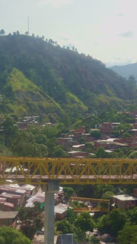 Cable car gondola lift traveling over the city of medellin, colombia, with views of mountains