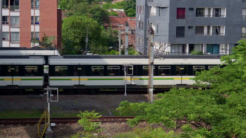 Public metro train traveling on tracks through the city of medellin, colombia, south america
