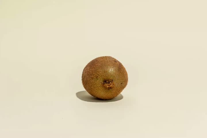 Fast motion slicing fresh ripe kiwi fruit half close up macro green juicy healthy organic food on white background 4K