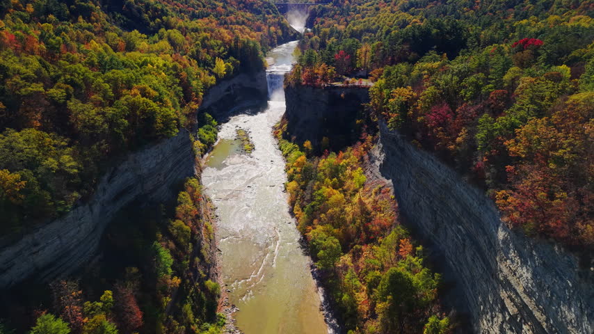 An aerial view shows Letchworth State Park canyon, river, waterfalls, and colorful autumn forest in New York.