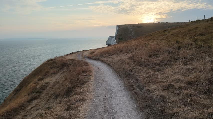 Forward camera walk on hiking trail at sunset along Jurassic Coast in Dorset UK