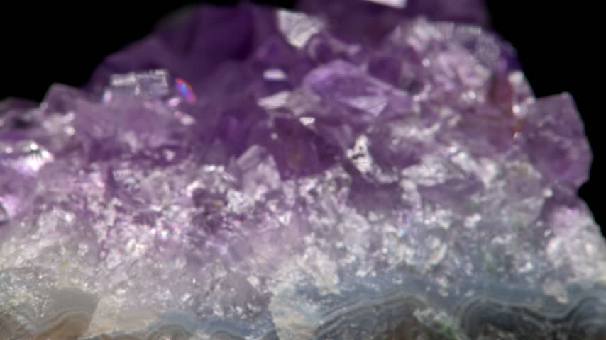 Amethyst (purple quartz) crystals sample against a black background	