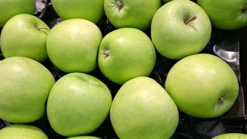 Fresh ripe green Granny Smith apples close up, organic sour fruits, healthy food ingredients and grocery store agricultural retail concept. Healthy snacks and desserts. Food for vegans and vegetarians