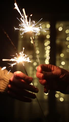 Happy new year video. Hands Holding Sparklers near Window Concept of New Year Eve video, Festive Celebration, Christmas Cozy Winter Night, Holiday Moments