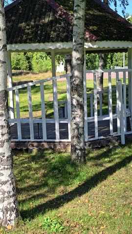 A white gazebo in a park setting, perfect for outdoor events or photography.