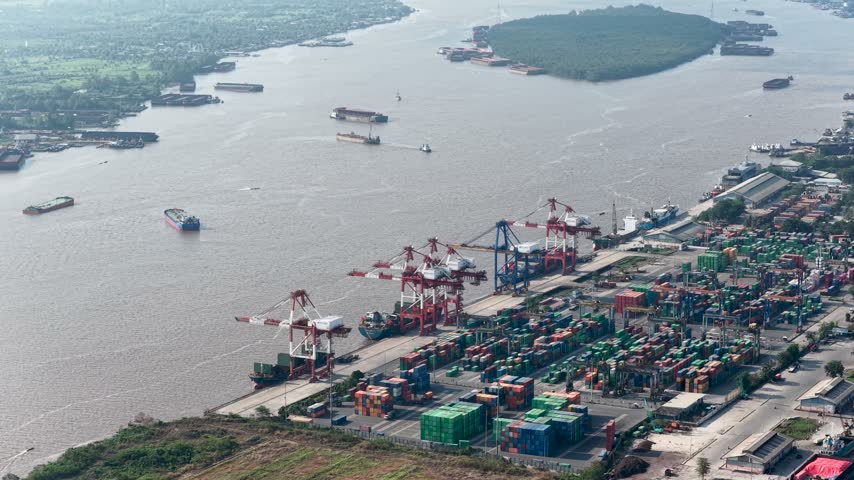 Cargo ships and cranes operating at the busy river port in Banjarmasin, South Kalimantan, Indonesia