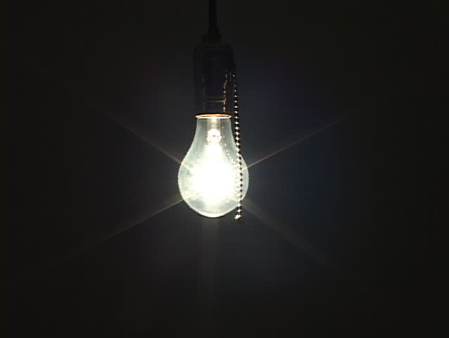 Medium shot of tungsten light bulb being turned off to black