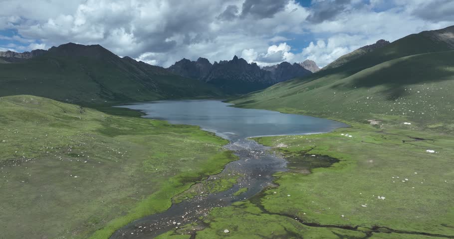 Beautiful green grassland and lake under cloudy sky	