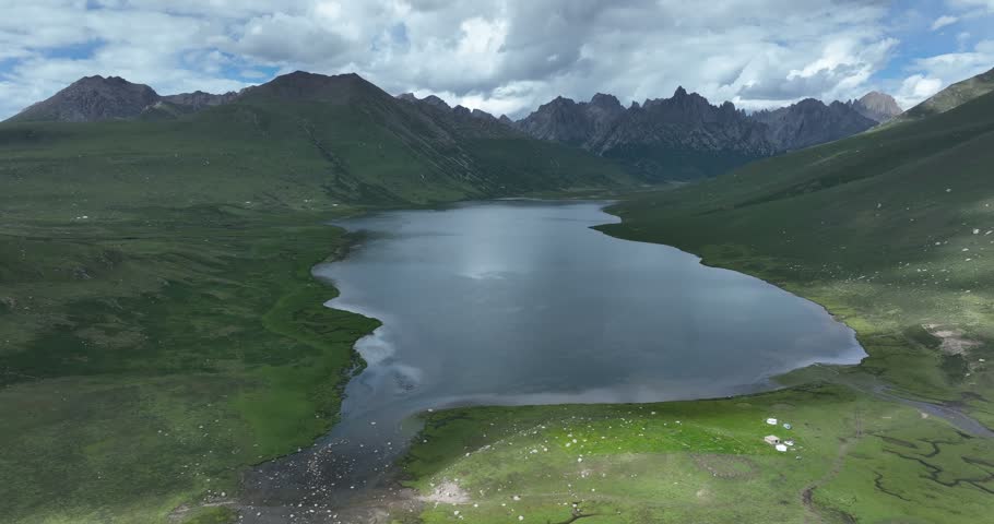Beautiful green grassland and lake under cloudy sky	