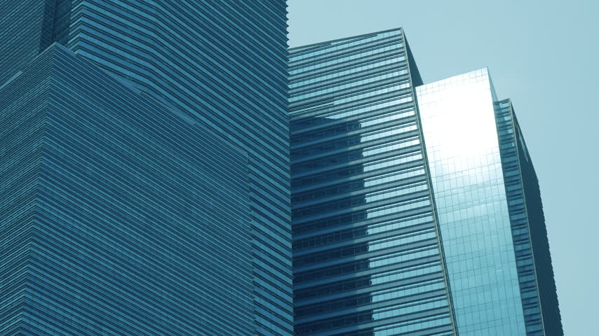Modern glass skyscraper facade showing geometric architectural patterns and reflections in Singapore.