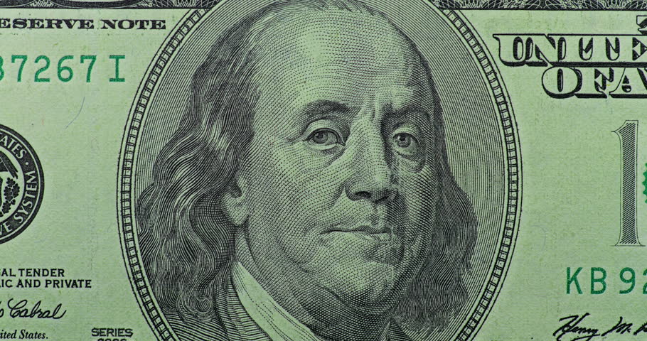 Benjamin Franklin portrait under green scan. 100 dollar bill with Benjamin Franklin portrait passes under moving green security scan. Zoomed close view highlights note, security glow, and crisp engraving.