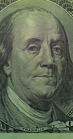 Benjamin Franklin on 100 Dollar Bill with Green Scan. Benjamin Franklin portrait on 100 dollar bill glows under moving green security scan. Banknote image shifts from top to bottom with sleek anti counterfeit effect.