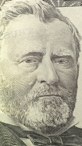 Ulysses S. Grant portrait on fifty dollar bill. Grant portrait fills fifty dollar bill detail with shifting color and fine engraving. U.S. currency close up delivers tense abstract look as tones change across printed face.