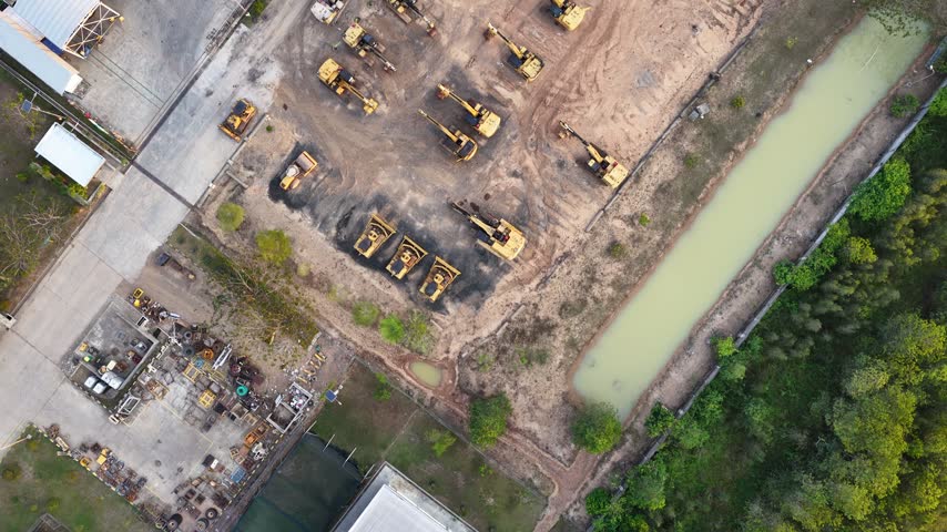 Excavators and heavy construction machinery parked neatly in a large open outdoor storage site