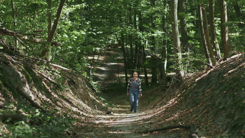 Lost Mid Adult Woman Checking Map on Smartphone in Forest