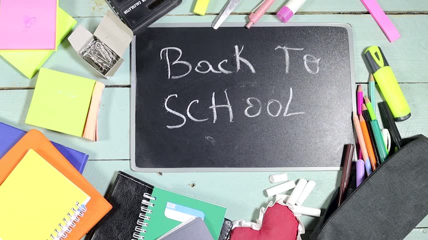 Back to School Chalkboard With ABC Letters and Colorful School Supplies on Wooden Desk