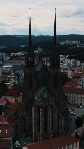 Aerial view of the Cathedral of Saints Peter and Paul in Brno, Czech Republic, set against a cityscape at twilight.