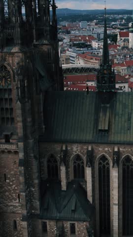 Aerial drone shot of St Peter and Paul Cathedral in Brno, Czech Republic, highlighting the gothic architecture and surrounding city roofs.