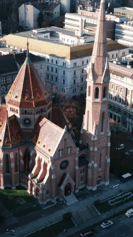 Aerial drone shot panning around the historic Calvinist Church located at Szilagyi Dezso Square in Budapest, Hungary.