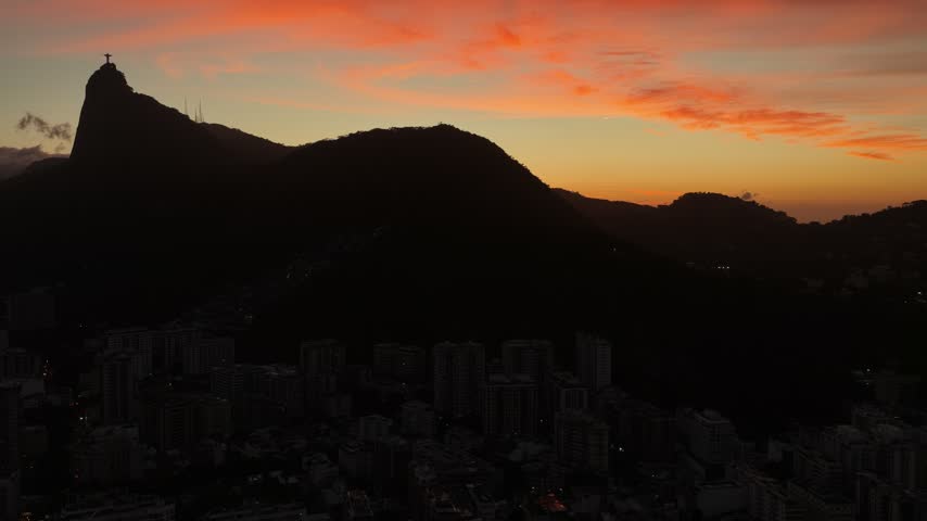 Aerial view of Christ the Redeemer silhouette at sunset over Rio de Janeiro, Brazil.
