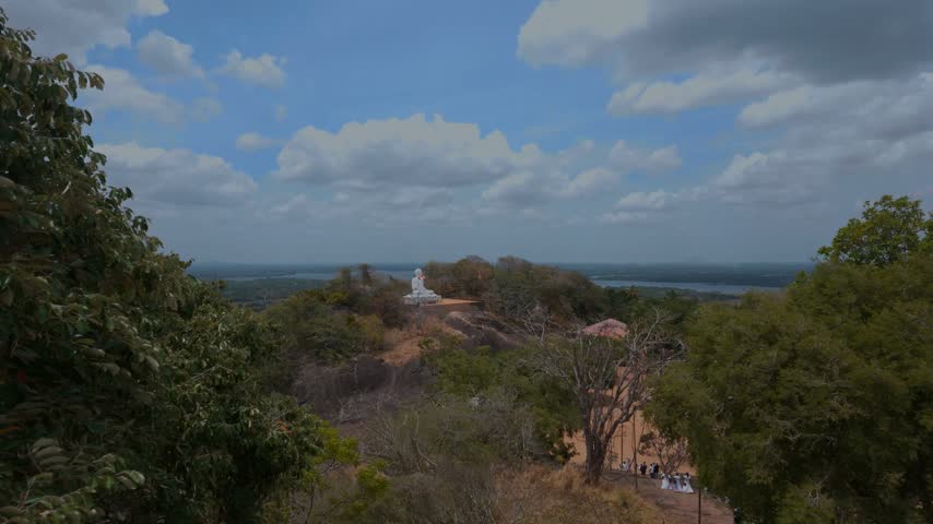 An incredible view of an ancient Buddha statue with Buddhist flags fluttering in the wind, Sri Lanka