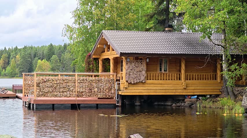 Small wooden cabin sitting on top of a lake, suitable for summer vacation or lake house concept.