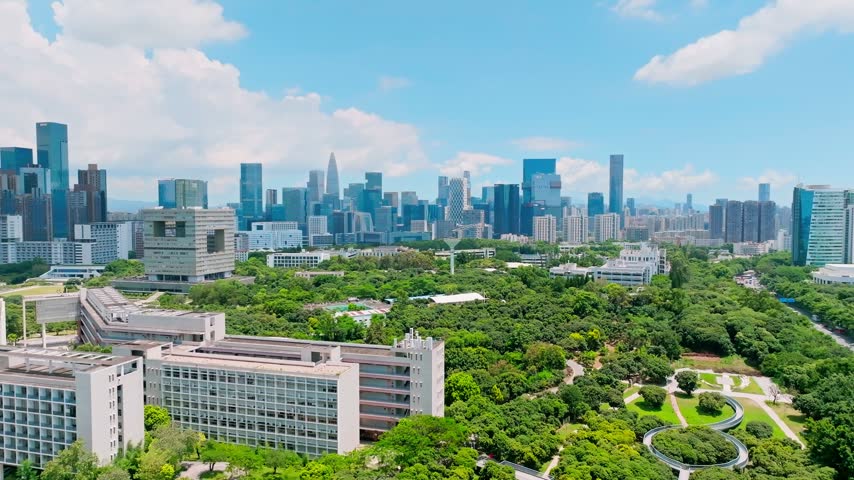 Aerial view of green university campus beneath a modern skyline in Shenzhen, Guangdong, China. The scene features Shenzhen University. Relevant to higher education and campus planning.
