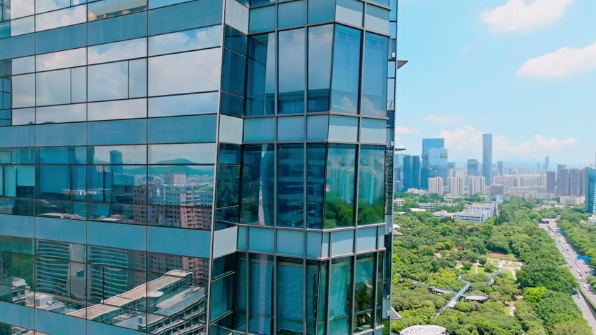 Aerial view of campus blocks and tree lined roads beyond glass in Shenzhen, Guangdong, China. The scene features Shenzhen University. Relevant to higher education and campus planning.