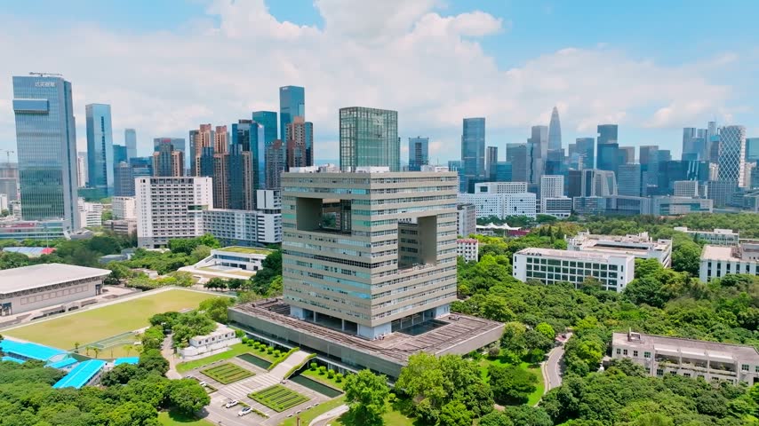 Aerial view of geometric campus tower amid landscaped grounds in Shenzhen, Guangdong, China. The scene features Shenzhen University. Relevant to higher education and campus planning.