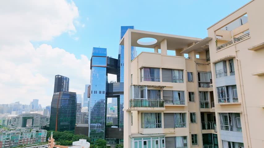Aerial view of connected office towers above residential rooftops in Shenzhen, Guangdong, China. The scene features Tencent Seafront Towers. Relevant to architecture and urban planning.