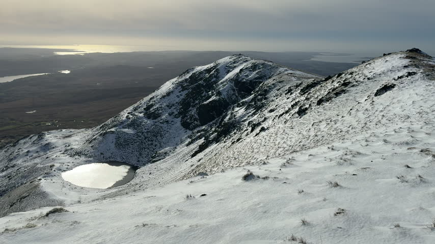 Mountains and snow in cumbria Lake District aerial view from top of mountain looking to Morecambe bay UK 4K
