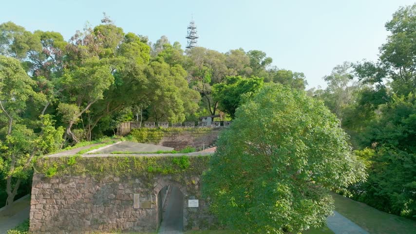 Elevated view of wooded fort terrace with stone steps and walls in Shenzhen, Guangdong, China. The scene features Chiwan Left Battery. Relevant to coastal defense heritage and history.