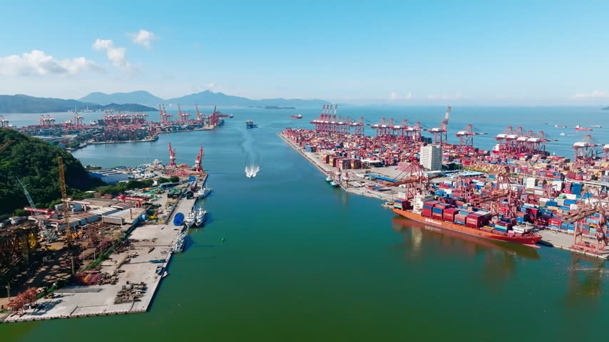 Aerial view of harbor channel between container port facilities in Shenzhen, Guangdong, China. The scene features Shekou Port. Relevant to maritime logistics and trade infrastructure.