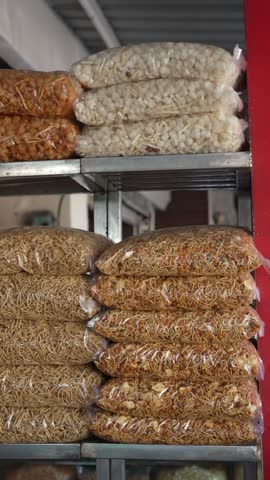 Assorted packaged namkeen and sev snacks stacked on metal shelves in an Indian shop